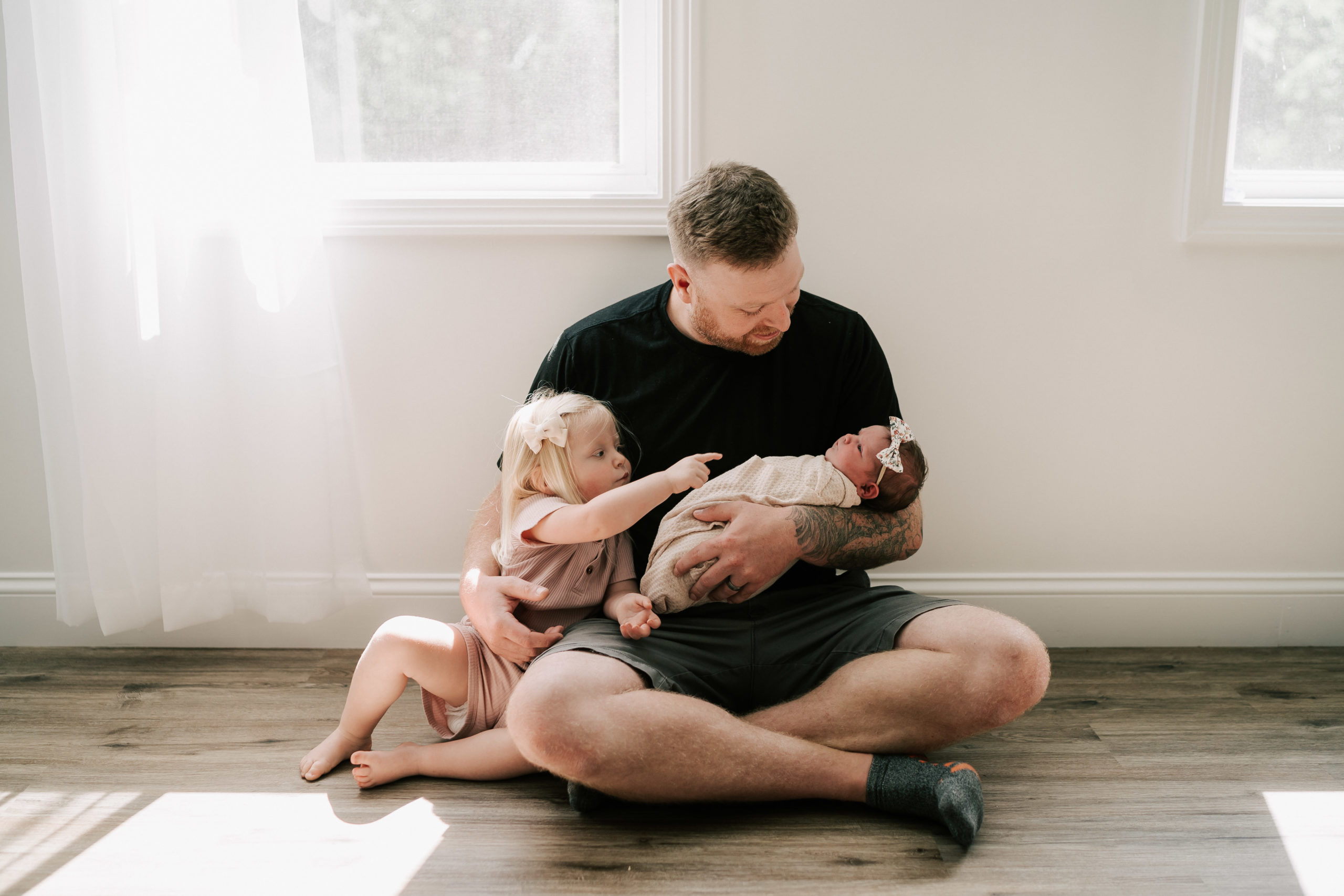 dad holding his daughters in boston photo studio